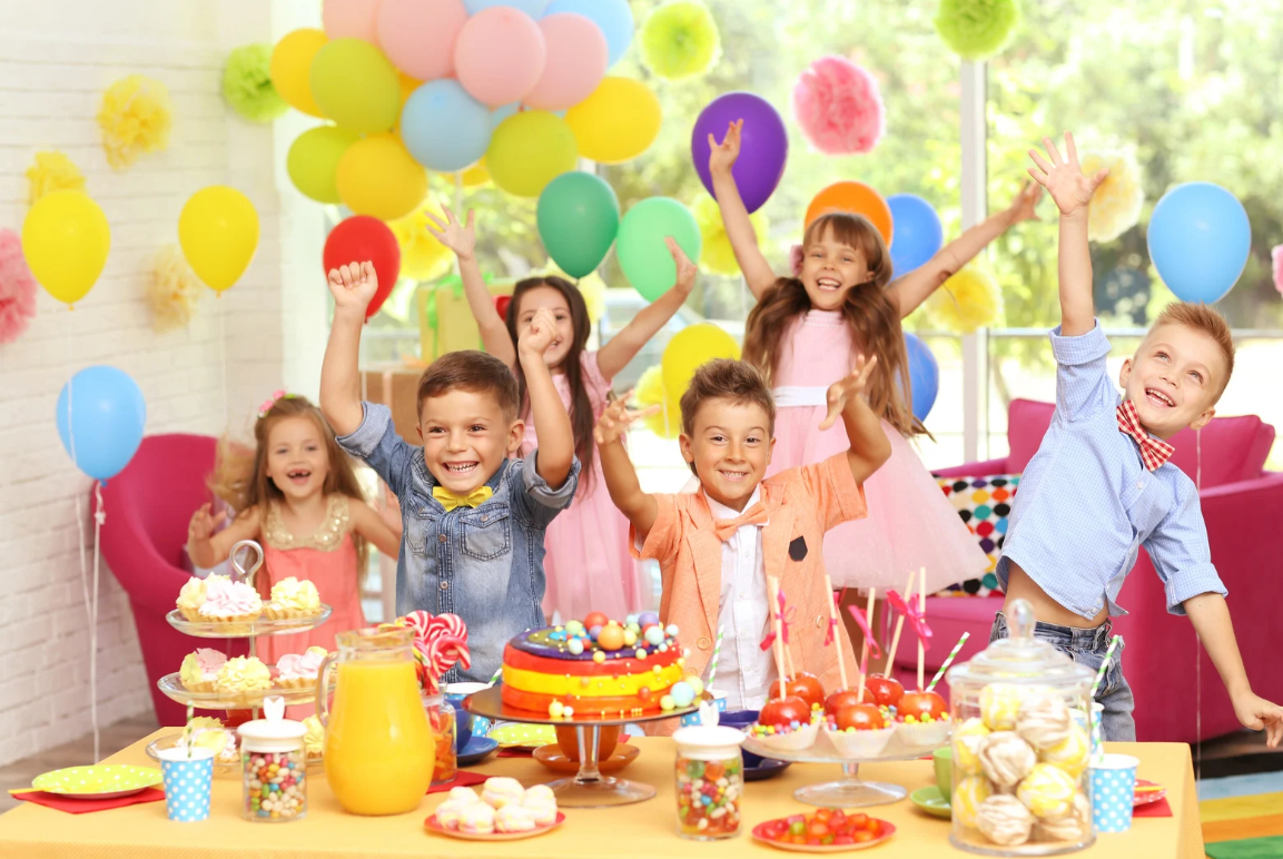 Enfants joyeux autour du buffet d'anniversaire
